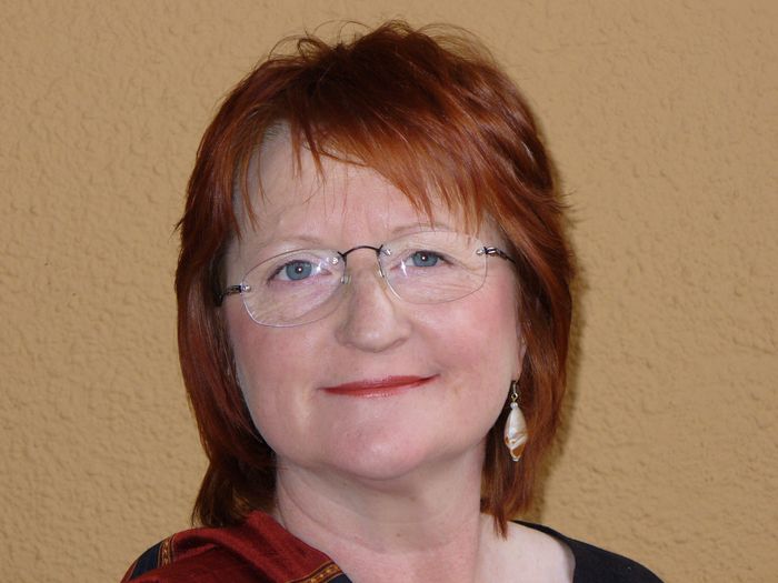 Die Kulturcafé-Mitarbeiterin Carmen Tillmann im Porträt, Frau mit Brille und längeren roten Haaren