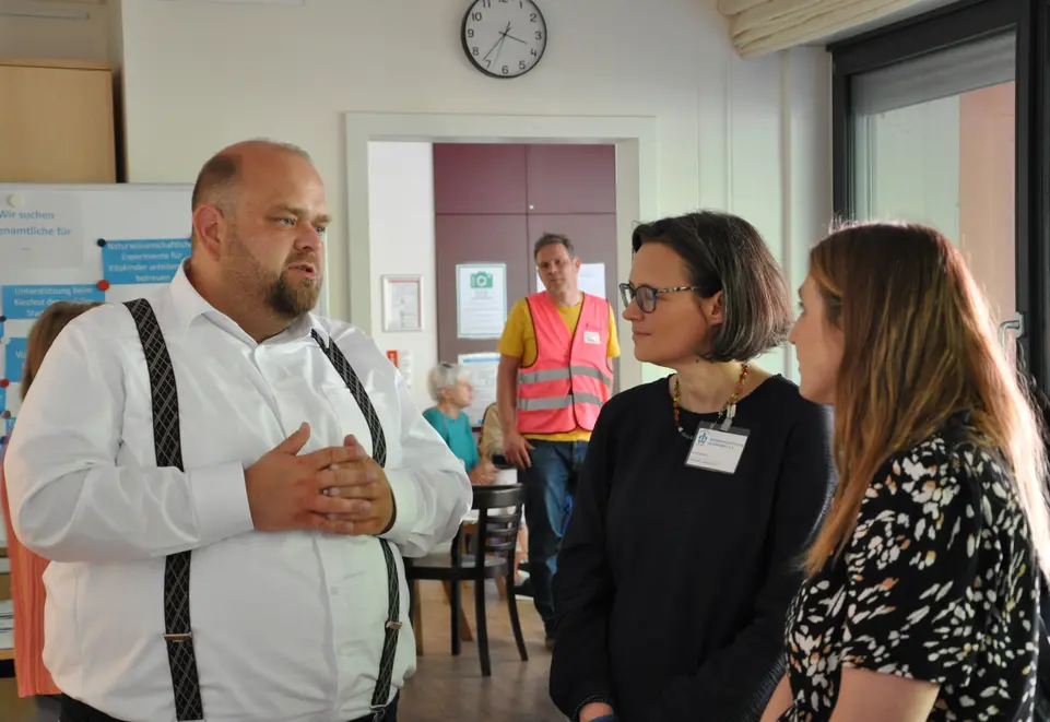 Ein Mann und zwei Frauen im Gespr&auml;ch