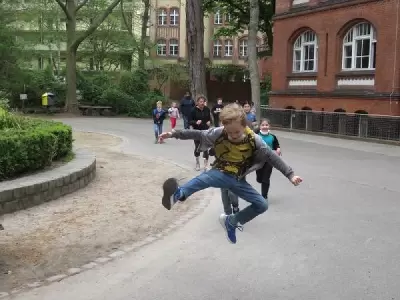 Kinder rennen auf den Schulhof, der erste macht einen Luftsprung