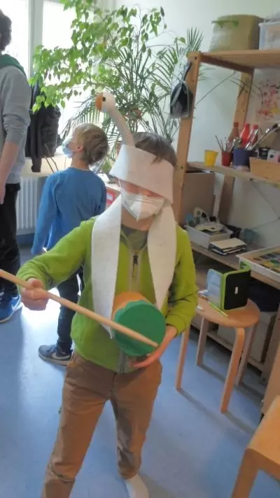 Kind als Gans verkleidet schl&auml;gt auf eine Trommel