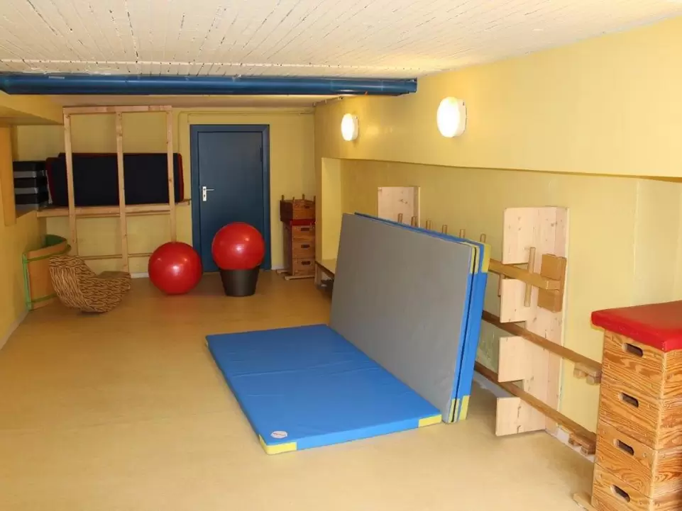 gelbes kleines Zimmer mit Turnmatten und B&auml;llen