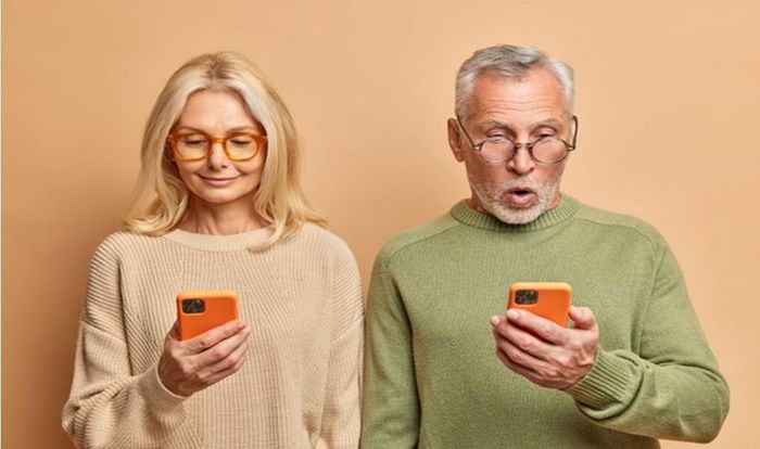 Zwei ältere Menschen schauen ratlos auf ihr Smartphone