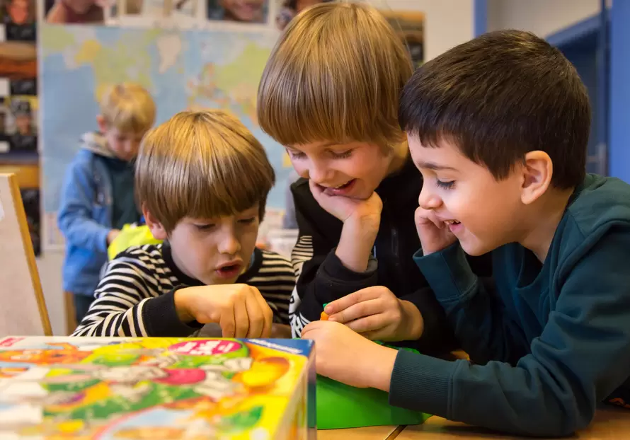 drei Jungs spielen ein Brettspiel