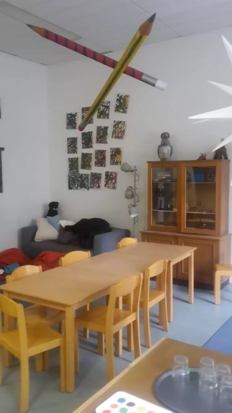 Raum mit Tischen und St&uuml;hlen, einem kleinen Sofa und einem alten Schrank 