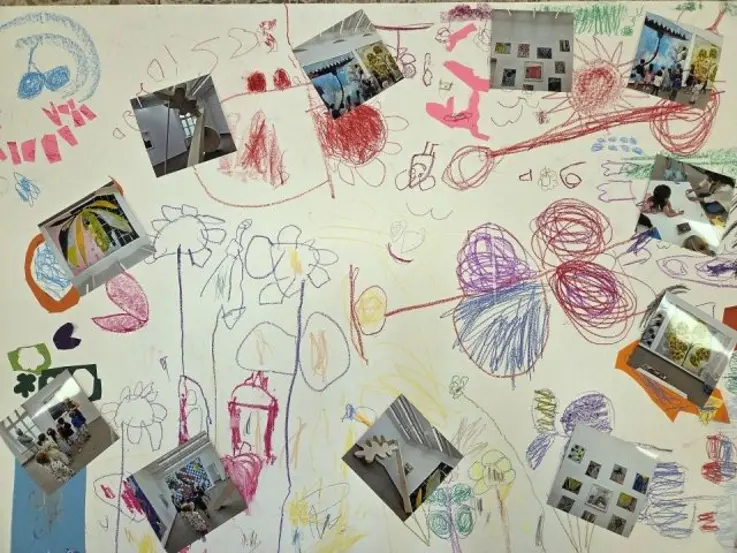 Das Foto zeigt ein gro&szlig;formatiges Blatt Papier mit bunten Kinderzeichnungen.