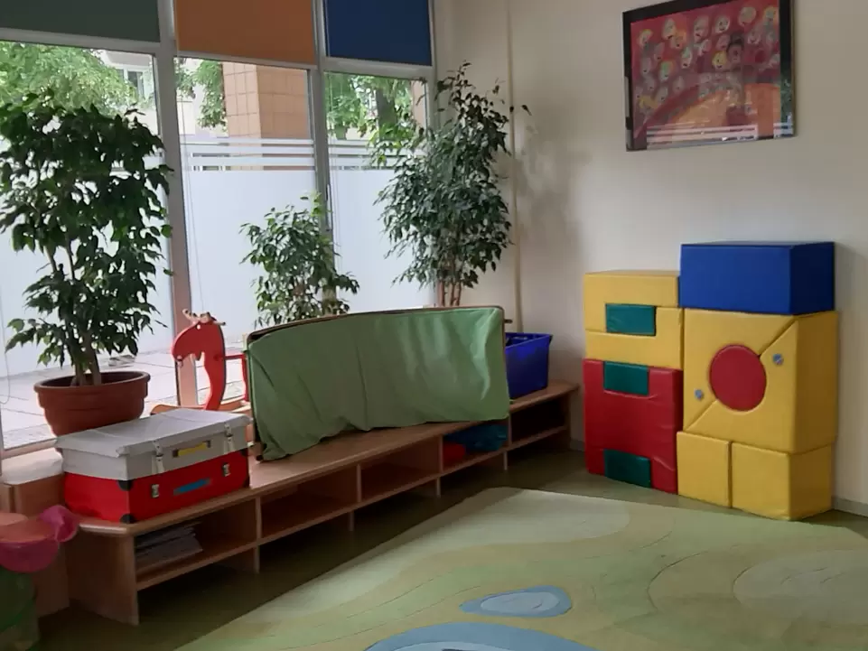 Raum mit bunten Bewegungselementen und Matten an der Wand