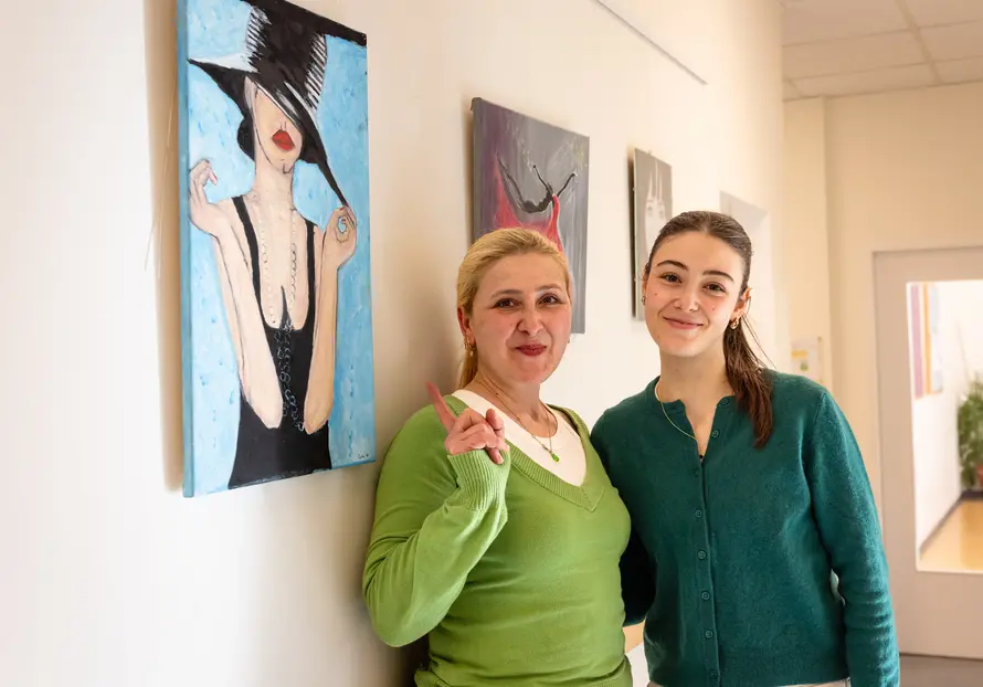 Frauen stehen vor einem gemalten Bild