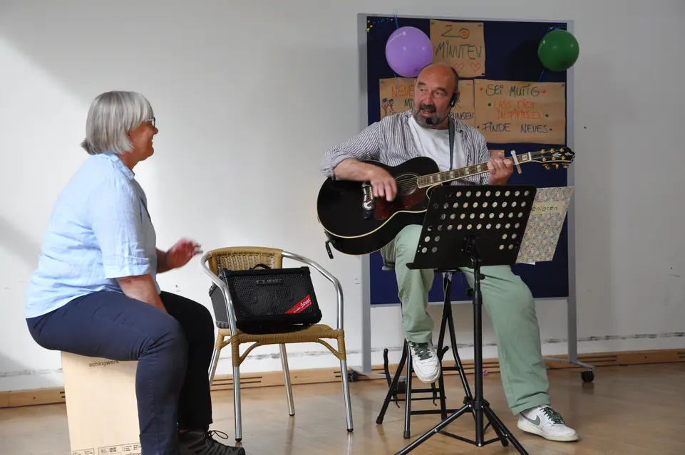 Ein Mann spielt Gitarre und eine Frau singt