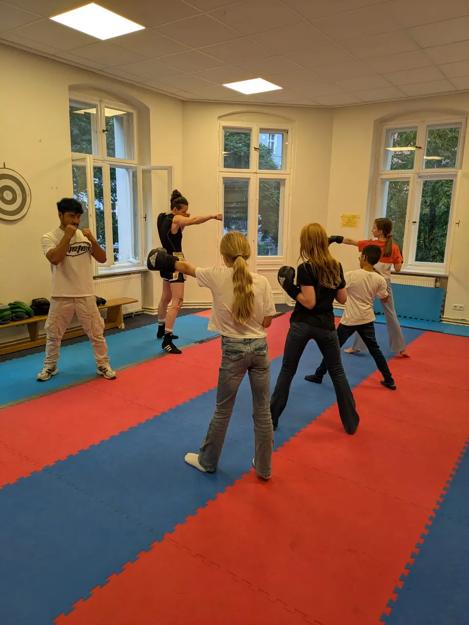 Zu sehen sind 4 Jugendliche und zwei Trainer beim Boxtraining 