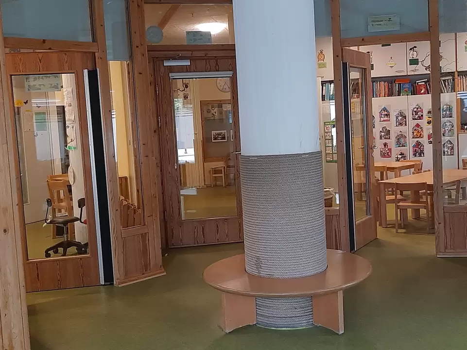 Raum mit S&auml;ule in der Mitte, mehrere T&uuml;ren mit Glas f&uuml;hren in angrenzende R&auml;ume