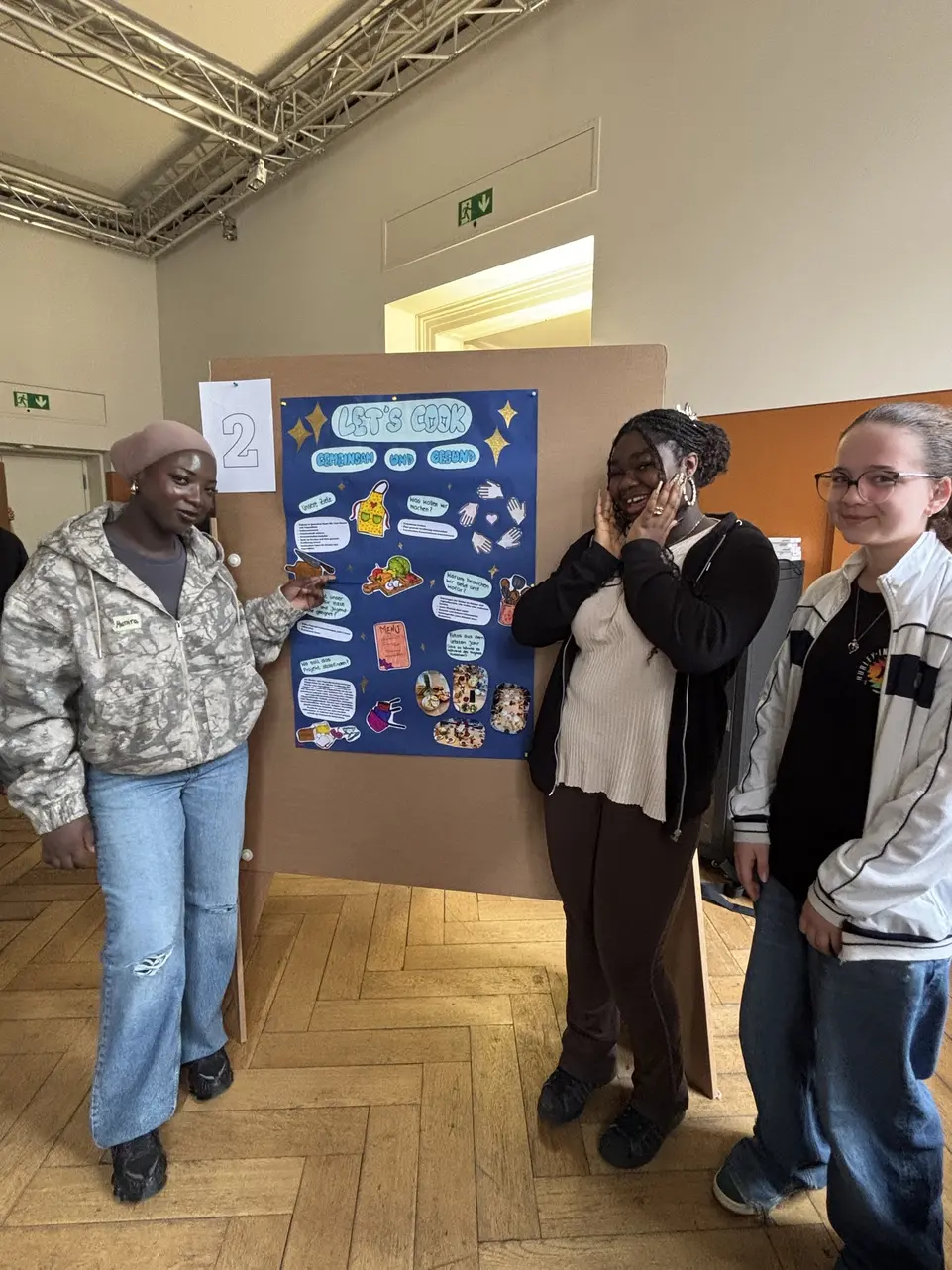 3 Jugendliche neben dem Projektplakat